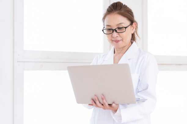 中年妇女，穿白大褂，带着笔记本电脑图片下载