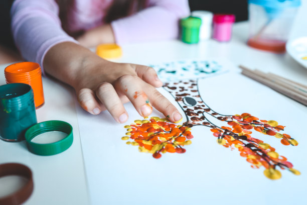 一个孩子在树上画树叶。用手指画画画的想法。在白色背景上为孩子们画手指画。小女孩用手指头画颜料。儿童发展观念。图片下载