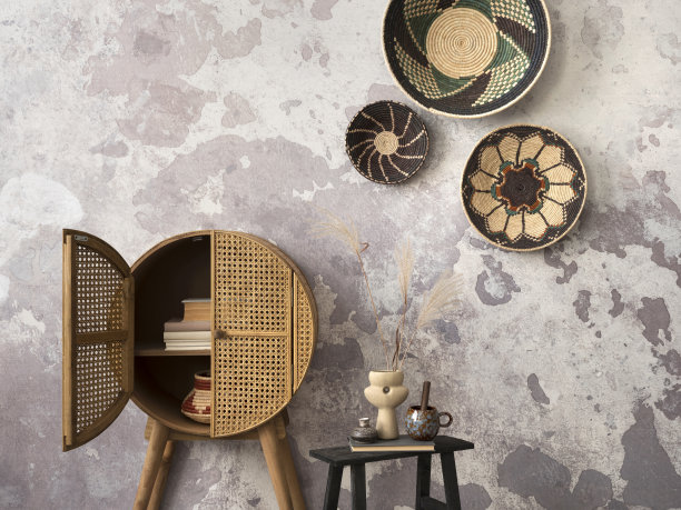 极简的民族客厅内部组成与彩色篮子，藤餐具柜，稻草花瓶，灰色混凝土墙和优雅的个人配件。家居装饰。模板。图片下载