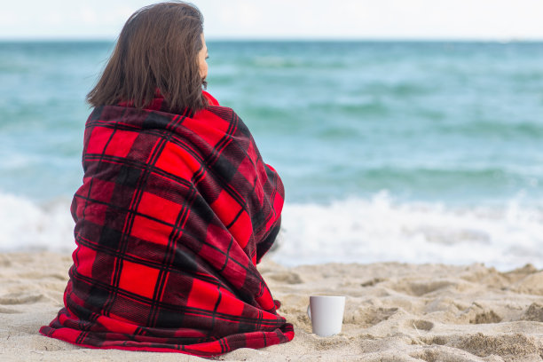 一个快乐的女人在海滩上的肖像。图片下载