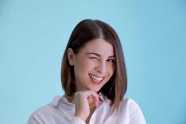 穿着白衬衫眨眼的女人的肖像图片下载