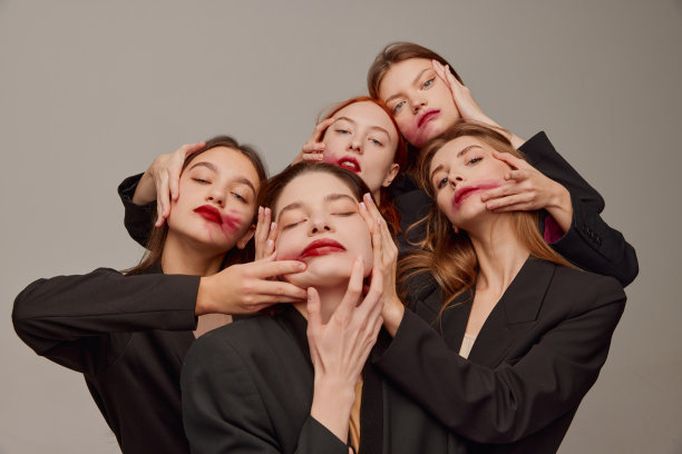 年轻美丽的女性在黑色夹克和红色口红化妆摆姿势在灰色背景。内心世界图片下载