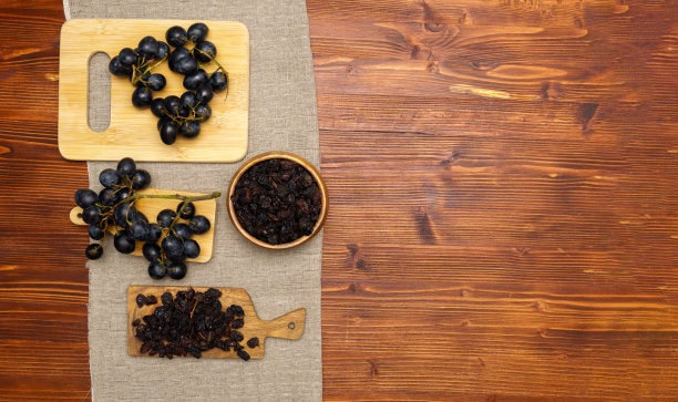 黑葡萄干与葡萄在木制背景，健康的零食，膳食产品。平的。本空间图片下载