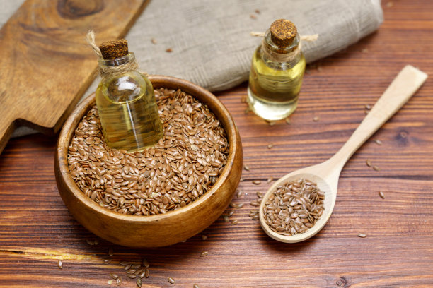 棕色的亚麻籽在勺子和亚麻籽油。亚麻油富含omega-3脂肪酸。图片下载