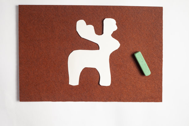 白色的鹿模板放在一张棕色的毛毡上图片下载