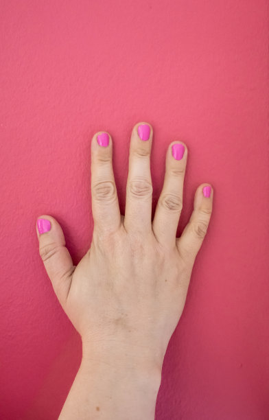 右手涂着粉色指甲油，墙上是粉色的。图片下载