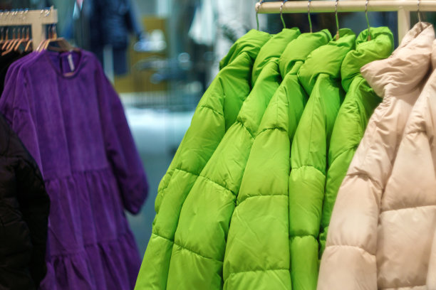 体育用品商店货架上的冬季彩色夹克和背心。有选择性的重点图片下载