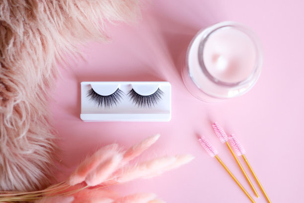 工具睫毛延伸在时髦的粉彩粉色背景。假睫毛，镊子和刷子。美容院。妆化妆品。俯视图，平铺图片下载