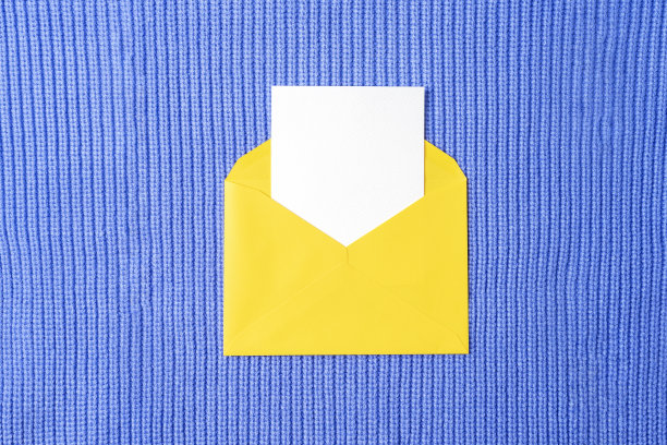 黄色信封，空白卡片，紫色针织物背景。生日，邀请，节日概念。俯视图，平铺图片下载