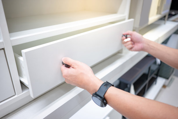 男性手在白色的柜子上打开抽屉图片下载