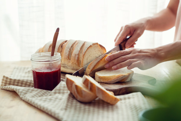 女人在砧板上切面包图片下载