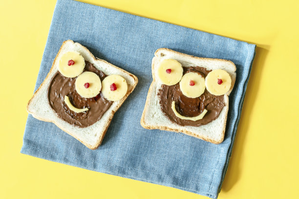 万圣节三明治吐司面包配花生酱，餐巾上的奶酪黄色背景特写。孩子，孩子，甜点，早餐，午餐食物图片下载