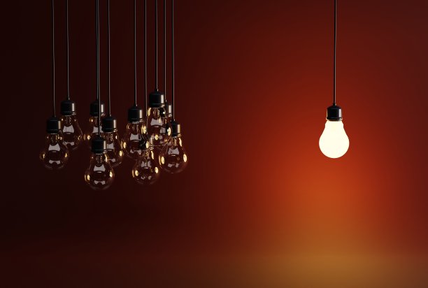 一个灯泡在许多熄灭的灯泡的背景。图片下载