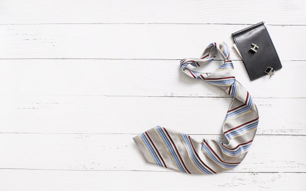 条纹领带和钱包在白色木制背景与复制空间。图片下载