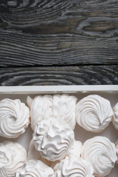 自制的西风。白色托盘上有棉花糖。立在黑松木板上。图片下载