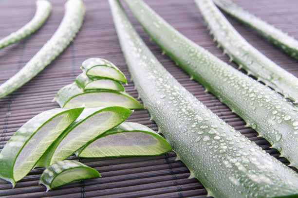芦荟凝胶与芦荟叶在木桌上。天然化妆品成分。木板上的新鲜芦荟，特写。图片下载