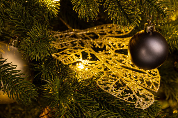 用球和花环装饰的漂亮的绿色圣诞树。特写照片。闪闪发光的背景。图片下载