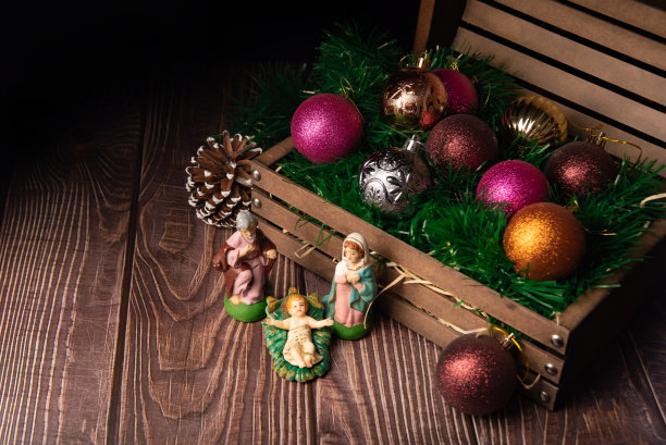 圣诞装饰品，把圣诞装饰品从箱子里拿出来连同一张古老的耶稣诞生场景，低调的照片，选择性的聚焦。图片下载