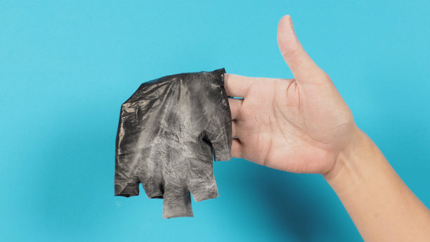 手握蓝色背景的黑色乳胶手套。图片下载