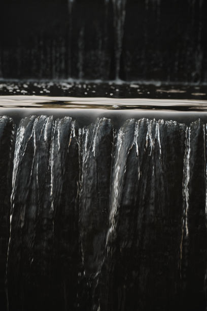 瀑布流在公园的水墙一个美丽的瀑布瀑布的城市喷泉特写倒图片下载