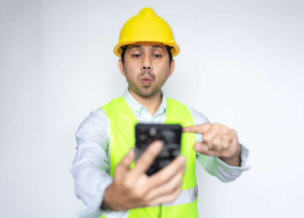建筑工人惊讶地看着智能手机图片下载