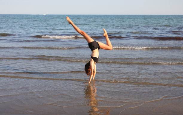 苗条的女孩背靠背做瑜伽冥想练习和做OM符号图片下载