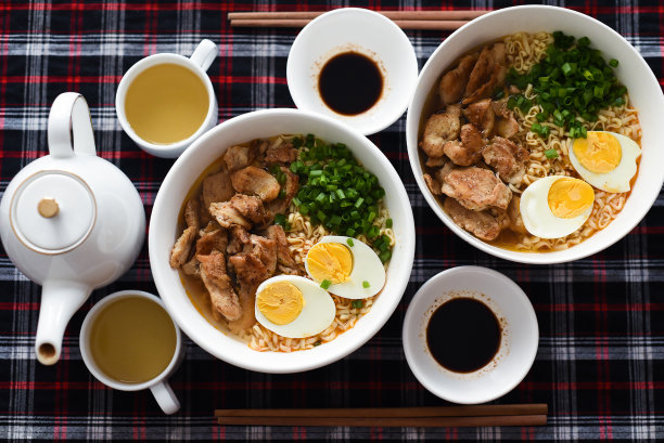 日式拉面配鸡肉和酱油，桌上有茶壶和绿茶图片下载