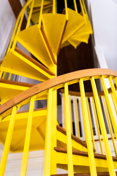 下面向上看的视角的老旧的楼梯在家庭内部与黄色的木制螺旋图案建筑图片下载