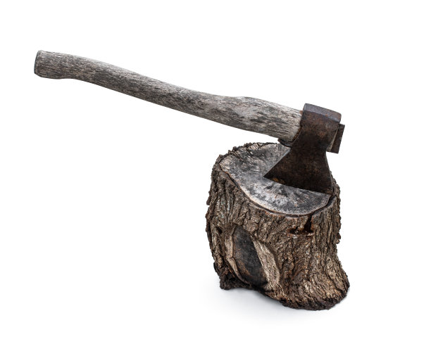 一把生锈的劈开的旧斧头插在树桩上，孤零零地躺在白色的地上图片下载