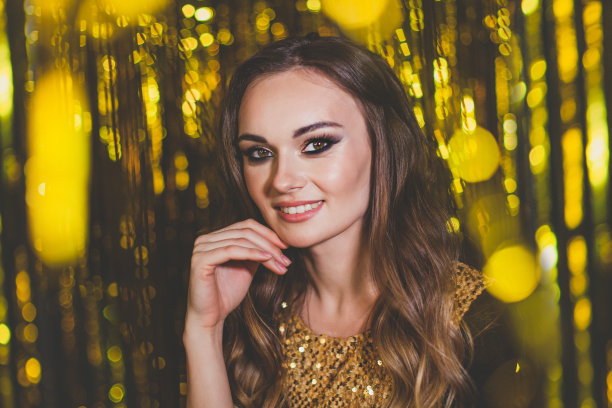 美丽的女性名人化妆在金色的散景背景图片下载
