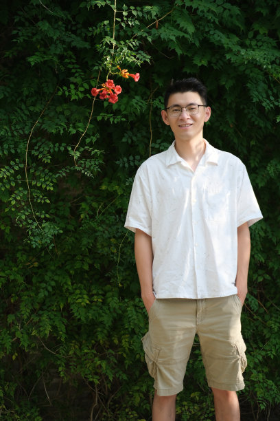 一名快乐的亚洲青年站在大菖蒲花前图片下载