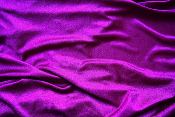 丝绒织物，类似丝绸。纺织品在褶皱和美丽的波浪。窗帘上有紫色，粉色，洋红色。缝制晚礼服、家具内饰、窗帘和室内装饰用材料图片下载
