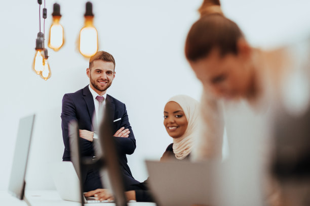 一个正式的商人和年轻的非裔美国女商人与他们的团队在现代创业办公室的肖像。市场营销的概念。多民族的社会。图片下载