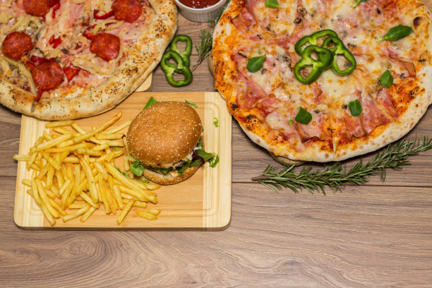 披萨和汉堡在木制背景上图片下载