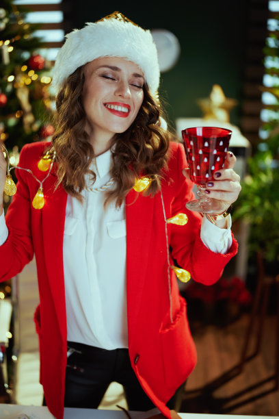 商业妇女在绿色的办公室与圣诞树跳舞图片下载