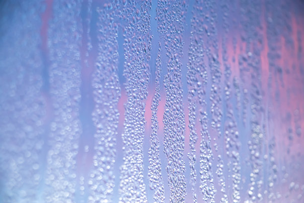 冬天雾气蒙蒙的玻璃质地。阳光下窗户上凝结的水滴。图片下载