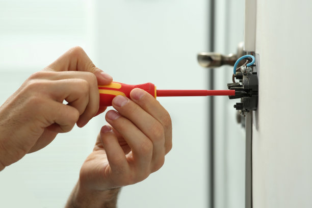 专业电工用螺丝刀修理室内电灯开关，特写图片下载