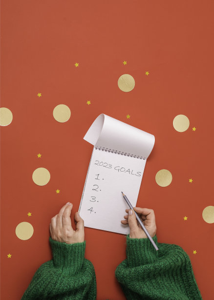 身穿红色背景绿毛衣的女子手里拿着记事本，这是一个可以复印的地方图片下载