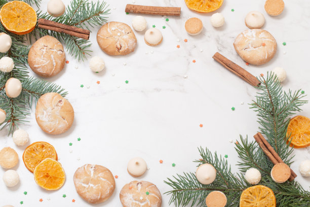 糖果和饼干与圣诞树的树枝在白色大理石背景图片下载