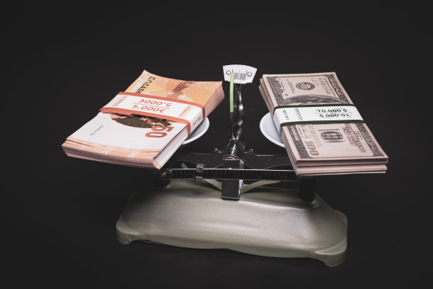 秤的一边是一捆美元钞票，另一边是一捆欧元钞票图片下载