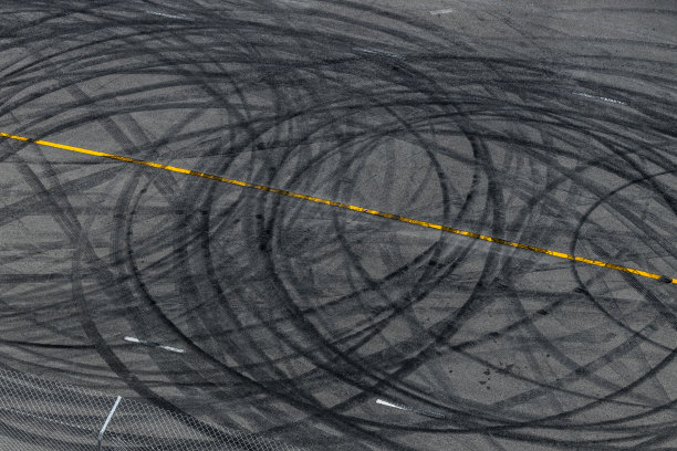 轮胎痕迹在柏油路面赛道纹理和背景，抽象背景黑色轮胎痕迹在赛道沥青路面打滑，轮胎标记在沥青路面打滑痕迹。图片下载