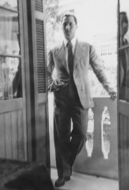 黑白照片摄于40年代:优雅的年轻人穿着西装站在家里的阳台上图片下载
