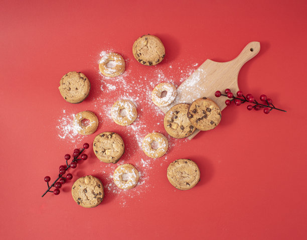 创意圣诞食物概念自制甜饼干，平铺在红色背景上。给整个幸福的家庭一顿美味的新年大餐。图片下载
