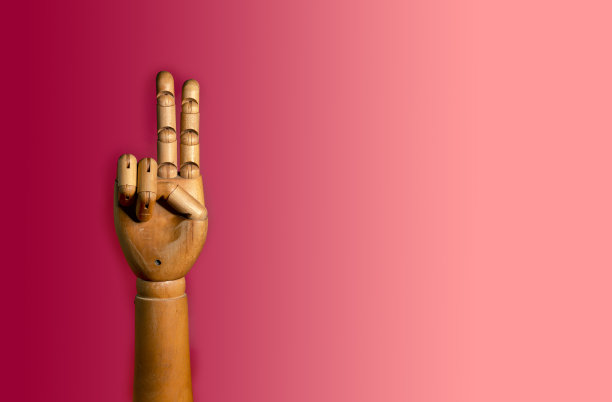 红色背景上的木制手。特写的木制人手-假体，..图片下载