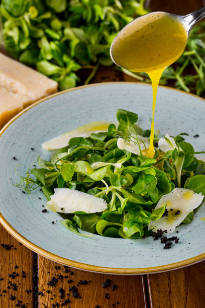 芝士沙拉，绿豆沙拉，木桌上一盘花芽配沙拉，一大块芝士和一匙酱汁图片下载