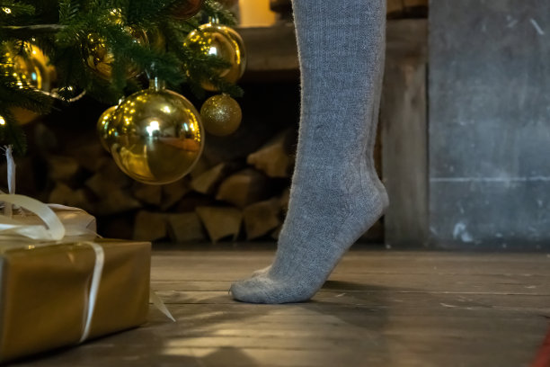 女人踮着脚尖站在圣诞树前图片下载