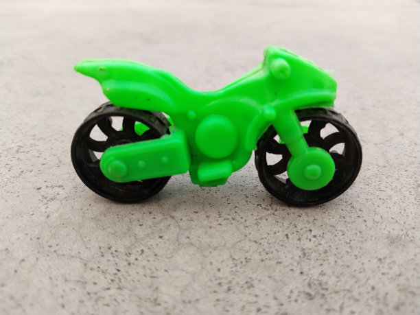 迷你玩具摩托车。塑料绿色玩具运动摩托车。平面玩具摩托车。简单的儿童摩托车玩具图片下载