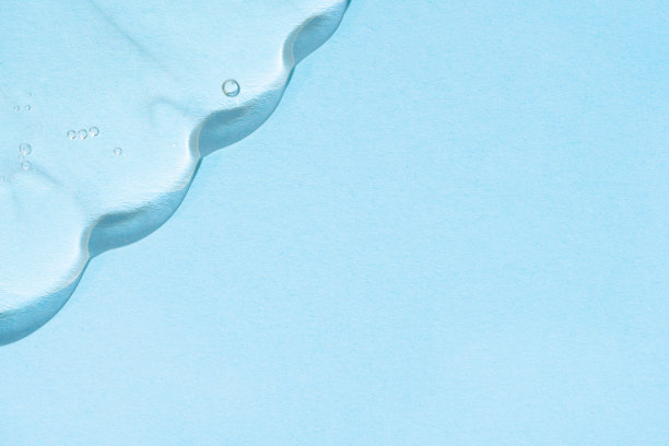 蓝色背景上有小玩意的液体凝胶。流动液体水分凝胶。图片下载