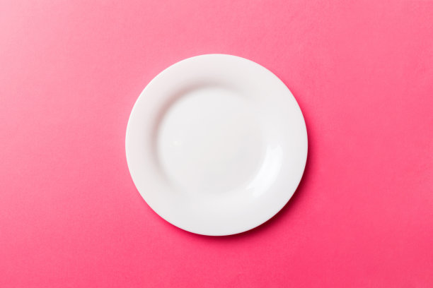顶视图孤立的彩色背景空圆白色盘子的食物。为你的设计腾出空间图片下载