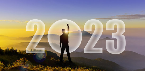 一个男人的剪影在山上举起手来挑战2022年。2023年新年快乐。日落时的男人剪影，日出时举手向山上的2023战斗展示变革、创业、目标、领导理念图片下载